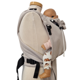 Babycarrier Mondstein in gray, adjustable half-buckle design, worn on mannequin with doll.