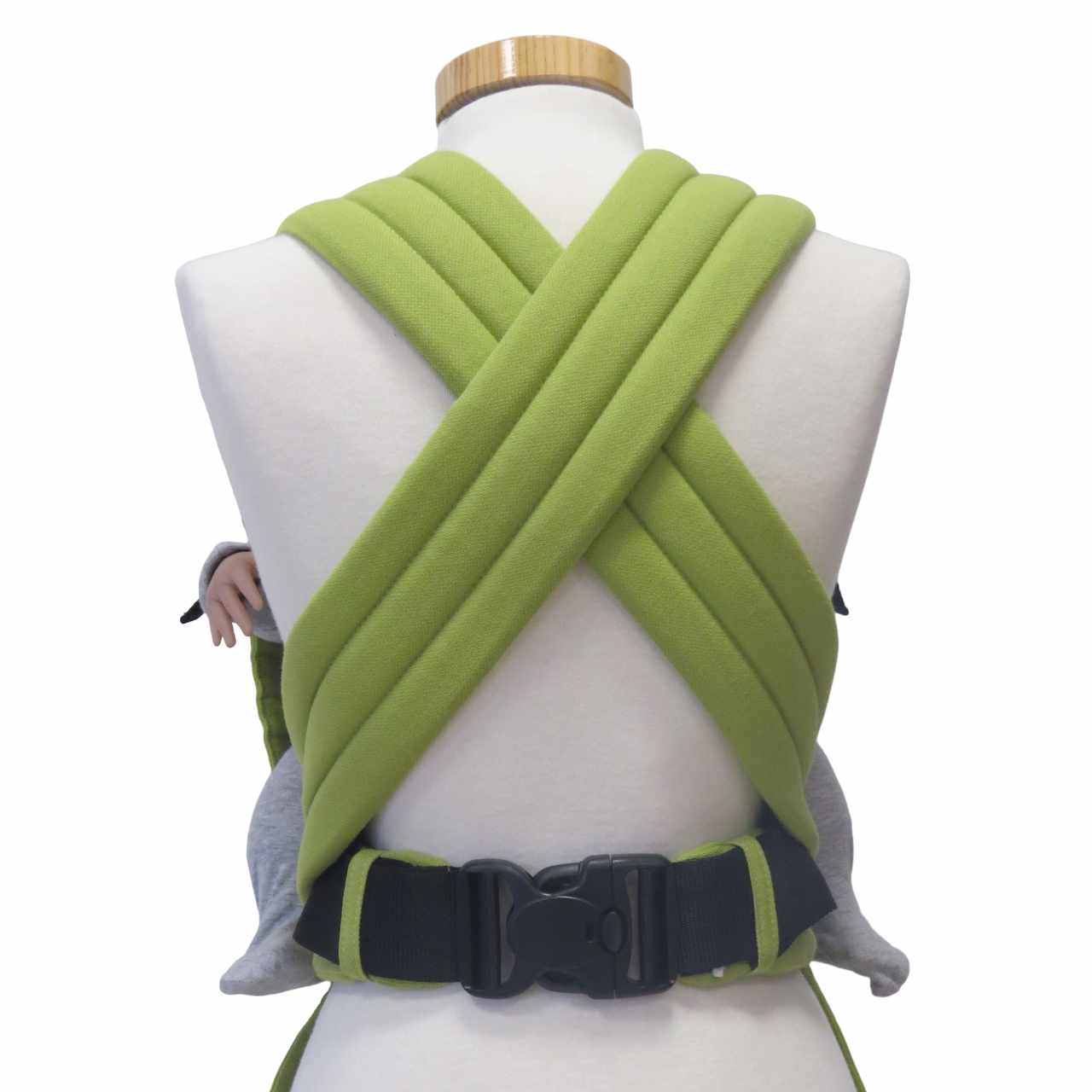 Optimal anpassbare Half-Buckle-Babytrage in Maigrün, gepolsterte Träger, Dreipunkt-Sicherheitsschnalle, aus 100% Baumwolle.