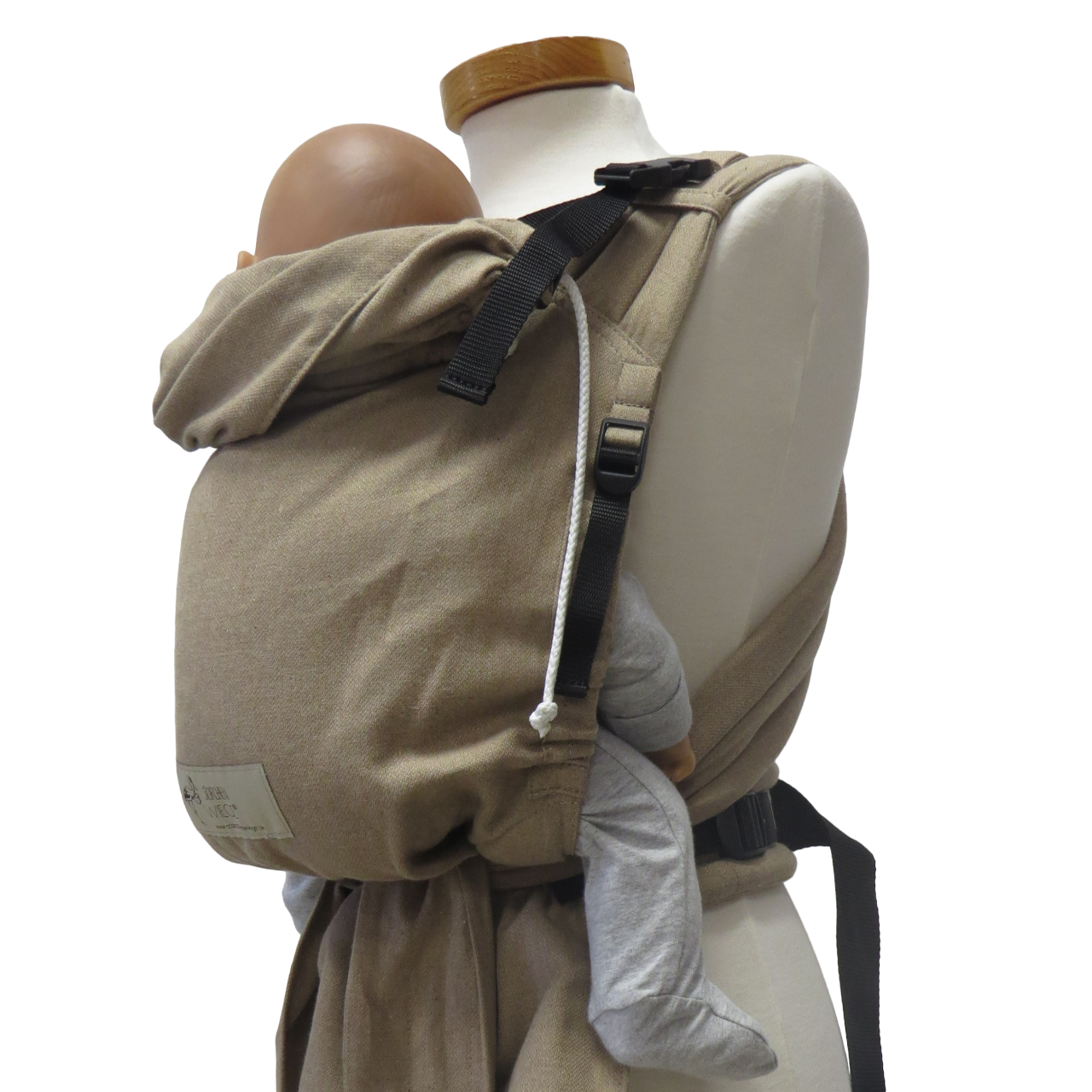 Babycarrier in sand color with adjustable straps and padded waistband, suitable from 3.5 kg to 15 kg, made from 100% cotton.