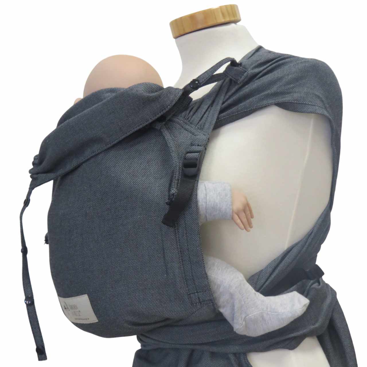 Wrapbabycarrier Graphit with adjustable shoulder and waist straps on mannequin, ideal for newborns to 15 kg, made of 100% cotton.