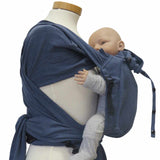 Wrapbabycarrier Jeans with adjustable wide shoulder and hip belt in denim style, holding baby.