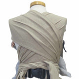 Natural-colored wrap baby carrier with wide shoulder straps and padded hip belt for newborns to 15 kg.