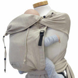 Wrapbabycarrier Natur in beige with broad shoulder straps and adjustable hip belt for carrying infants safely and comfortably.