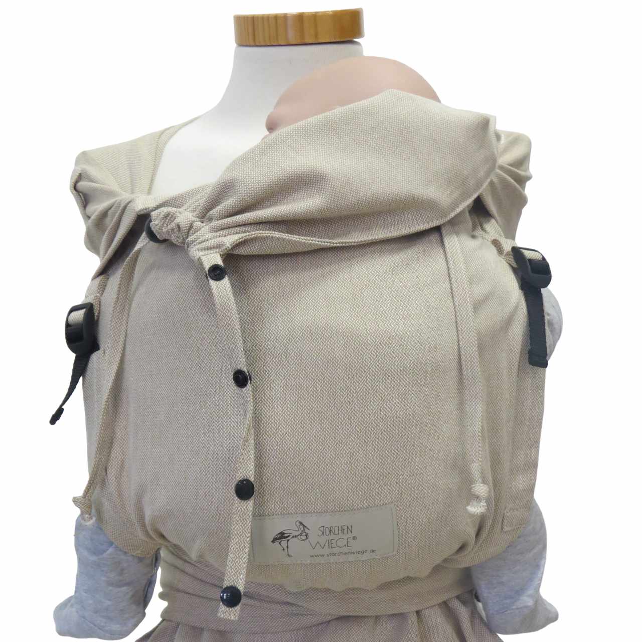 Natural-colored wrap baby carrier with wide shoulder straps and buckle waist belt, suitable from birth to 15 kg, made of 100% cotton.