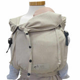 Natural-colored wrap baby carrier with wide shoulder straps and buckle waist belt, suitable from birth to 15 kg, made of 100% cotton.