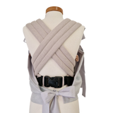 Storchenwiege Tragecover in light grey on a mannequin showcasing adjustable straps and soft material, ideal for keeping baby warm.