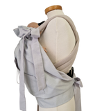 Storchenwiege Tragecover in light gray on mannequin, practical baby carrier accessory for cold weather.