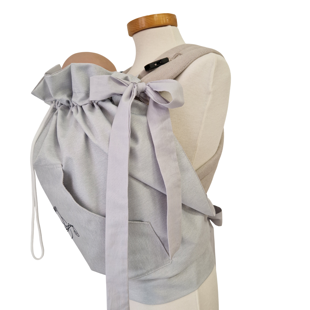 Storchenwiege Tragecover in light grey on mannequin, showing adjustable drawstrings and soft material.