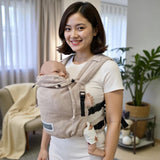 Mother carrying baby in Valeno Mondstein full buckle baby carrier indoors