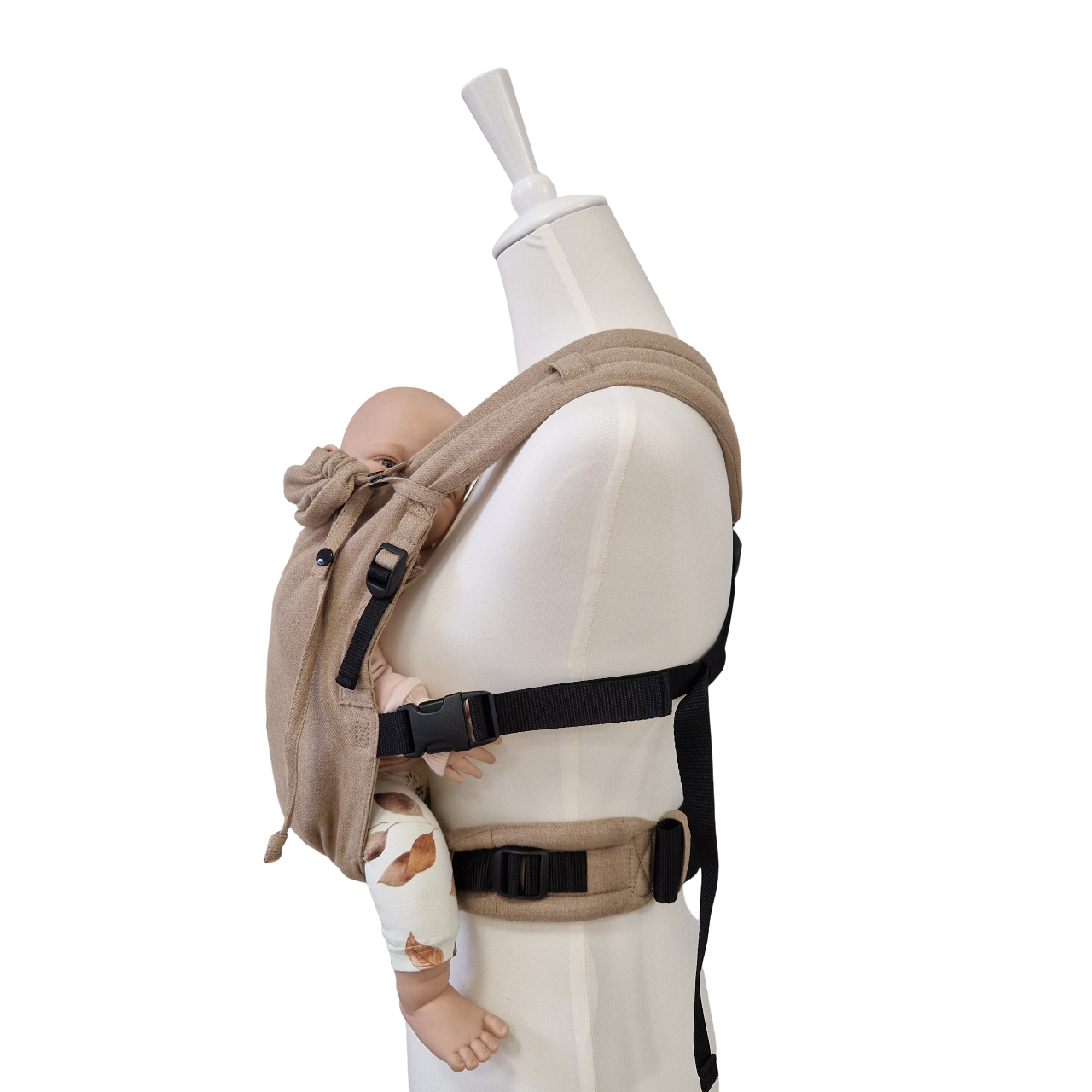 Valeno Sand baby carrier in beige with full buckle and padded straps carrying a doll in ergonomic front position