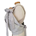 Storchenwiege Tragecover in light gray on mannequin, practical baby carrier accessory for cold weather.