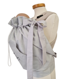 Storchenwiege Tragecover in light grey on mannequin, showing adjustable drawstrings and soft material.