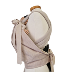 Storchenwiege Tragecover Natur protecting baby in carrier, offering warmth and weather protection with adjustable fit.