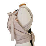 Storchenwiege Tragecover Natur protecting baby in carrier, offering warmth and weather protection with adjustable fit.