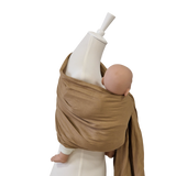 Beige Leinen-RingSling baby carrier wrapped around mannequin holding a baby doll securely and comfortably