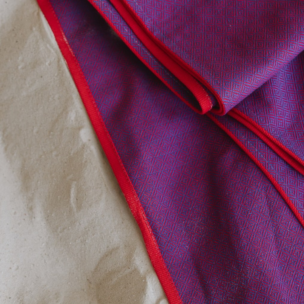 Ringsling Leo Violett aus Baumwolle mit zartem Webmuster.