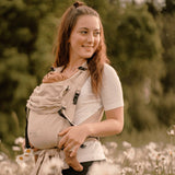 Adaptable natural Babycarrier, half-buckle design, 100% cotton, supports 3.5-15 kg, padded straps and waistband.