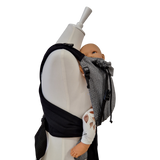 Babycarrier Leo in schwarz-weiß mit gepolsterten Trägern und sicherem Bauchgurt, gesunde Anhock-Spreiz-Haltung