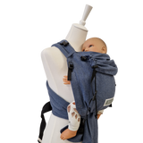 Babycarrier Jeans aus Baumwolle in Jeans-Optik mit gepolsterten Trägern und Brustgurt für gesunde Anhock-Spreiz-Haltung bei Neugeborenen.