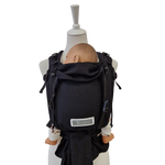 Schwarze Babytrage Leo Schwarz mit gepolsterten Trägern und gesunder Anhock-Spreiz-Haltung für Neugeborene bis 15 kg