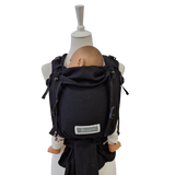 Schwarze Babytrage Leo Schwarz mit gepolsterten Trägern und gesunder Anhock-Spreiz-Haltung für Neugeborene bis 15 kg