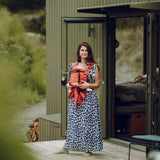 Frau trägt Baby mit BabyCarrier Terra vor dem Bauch draußen vor modernem Haus